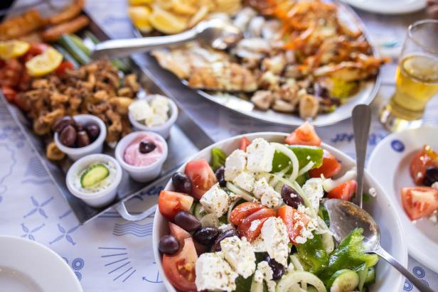Greek salad in bowl and seafood on table